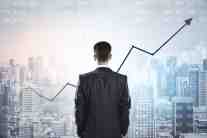 Businessman viewing rising financial graph over a modern city skyline