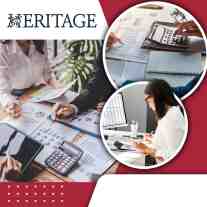 Accountants reviewing financial reports, spreadsheets, and bookkeeping records while analyzing business finances in an office setting.