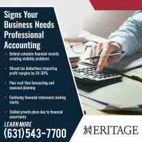 Business professional using a calculator and financial documents illustrating signs a company needs professional accounting services.